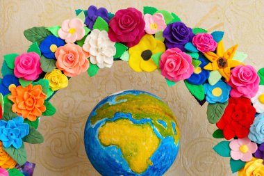 A bright wreath of paper flowers with a globe - a symbol of creative decor for the classroom clipart