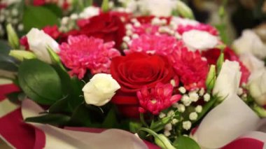 Parlak bir buket kırmızı gül ve pembe kasımpatı. Her yaprağın içinde aşk ve tutku