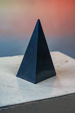 Gizemli piramit: Mat siyah taşın üzerinde ışık ve gölge oyunu.