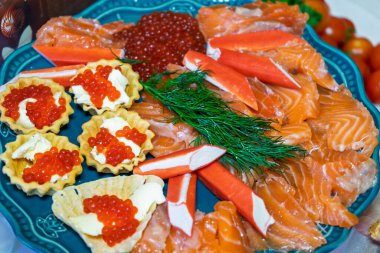 A vibrant seafood platter displays slices of fresh salmon, crab sticks, and caviar-filled pastries. clipart