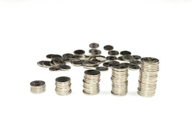 Çeşitli madeni paralar beyaz bir yüzey üzerinde düzenli olarak düzenlenir, farklı yükseklik ve miktarlarda sergilenir. Düzenlemede tasarruf ve mali planlama vurgulanıyor. Ukrayna parası