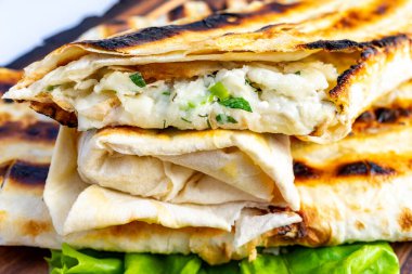 Lezzetli ızgarada bol miktarda kremalı peynir ve taze otlar sergileniyor. Açık havada servis edilir. Güneşli bir günde çekici dokular ve canlı renkler sergilenir..