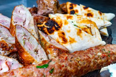 Açık hava toplantısı için kızarmış ekmeğin yanında sosis ve kesikler de dahil olmak üzere çeşitli ızgara etler de düzenleniyor. Canlı renkler ve dokular iştah açıcı bir görüntü yaratır..