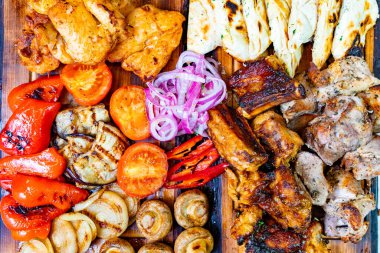 Canlı bir ızgara et ve çeşitli sebzeler ahşap bir tepside düzenlenir. Renkli ziyafette tavuk, biftek, biber ve soğan var. Yaz yemeği için mükemmel..