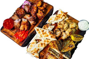 Izgara tavuk, balık ve ahşap tahtalarda çeşitli etler yanında da flatekmek ve süslemeler. Bu canlı gösteri, toplantılar ve kutlamalar için ideal bir ziyafet niteliği taşıyor..
