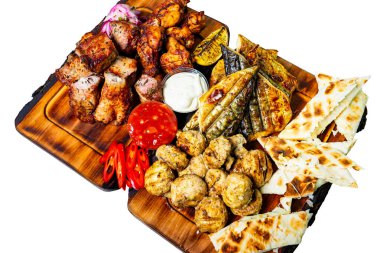 Taze sebzelerle süslenmiş ve yanında soslarla birlikte çeşitli ızgara etlerden oluşan canlı bir ziyafet. Şenlikli bir toplantı veya sıradan bir yemek sırasında paylaşmak için mükemmel..