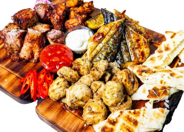 Tavuk ve balık da dahil olmak üzere canlı bir ızgara ahşap bir tahtanın üzerinde zarif bir şekilde düzenlenir. Etkinlikler arasında soslar, soslar ve taze sebzeler, sergilenen mutfak çeşitliliği yer alıyor..