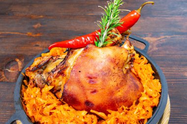 Taze biberiye ve baharatlı kırmızı biberle kaplanmış baharatlı lahanayla süslenmiş ahşap bir masada zarif bir şekilde sunulur..