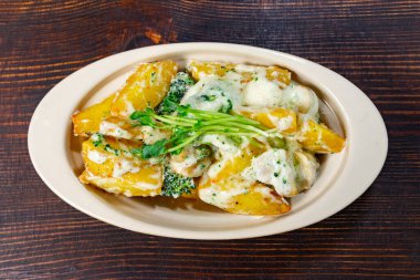 Brokoli soslu ve taze otlarla süslenmiş kremalı patates dilimleri doyurucu bir yemek sunar. Bu yemek evde sıcak bir akşam yemeği ya da arkadaşlarla sıradan bir toplantı için mükemmel..