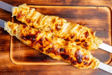 Taze pişmiş hamur işi vitrinleri altın gibi çıtır çıtır bir dış görünüş. Tahtaya yerleştirilmiş, sıcaklığı ve çekici bir aroması var, günlük toplantılarda paylaşmak için mükemmel..