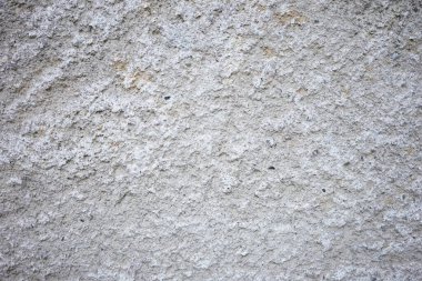 Kalıplı gri bir duvarın yakın çekim görüntüsü pürüzlü yüzeyini gösteriyor. Renk ve desendeki ince farklar bu şehir ortamında görsel bir ilgi yaratıyor.