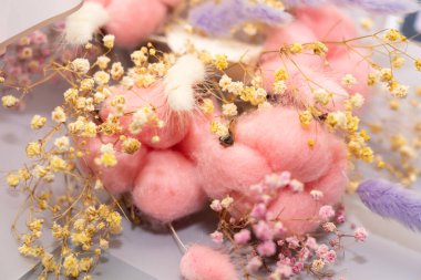 Zarif kurumuş çiçeklerin ve yumuşak pembe pamukların sergilendiği çarpıcı bir çiçek aranjmanı, canlı ama dingin bir görüntü yaratıyor. Ev dekorasyonu ya da hediye vermek için mükemmel..