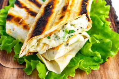 Taze ızgara yumuşak ekmek, canlı yeşil marul yatağında sunulan kremalı peynir ve otların zengin bir karışımıyla doludur. Hafif bir yemek veya atıştırmalık için mükemmel..