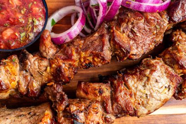 Küçük bir kase taze salsa sosu ve ince dilimlenmiş kırmızı soğanın yanında sulu ızgara et sunulur. Bu iştah açıcı yemek sağlıklı bir akşam yemeği için mükemmel..