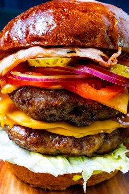 Ağız sulandıran bir hamburgerde iki sığır eti köftesi, erimiş peynir, kıtır pastırma, marul, domates, turşu ve soğan vardır. Sağlıklı bir yemek için mükemmel..