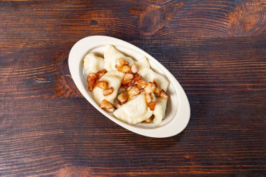 Kıtır kıtır pastırmalı yumuşak hamur köfteleriyle dolu bir tabak kırsal bir ahşap masada oturur. Sıcak, davetkar bir yemek için mükemmel..