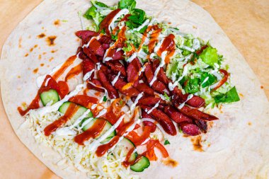 Taze salata, salatalık ve sosla serpilmiş taze salata parçalarıyla dolu bir paket. Canlı renkler ve dokular ağız sulandırıcı bir deneyim yaratıyor, hızlı bir yemek için mükemmel..