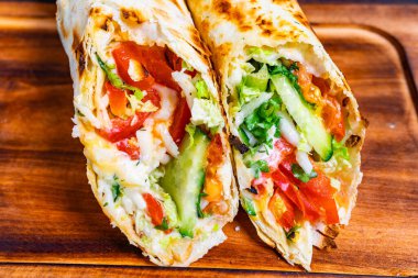 Yeni yapılmış iki paket renkli sebze ve soslar sergiliyor. Canlı domatesler, gevrek marul ve salatalıklar lezzetli ve doyurucu yemekleri arttırır..