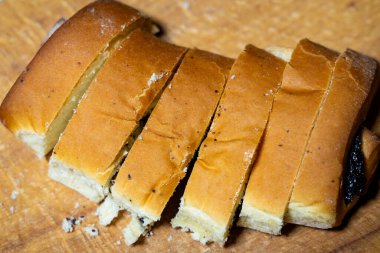 Sıcak ekmek, tahta bir tahtanın üzerinde, eşit parçalara ayrılır. Kabuğu altın kahverengidir. Yumuşak ve kabarık bir iç yapısı vardır. Sandviç veya tost için ideal..