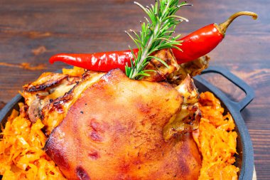 Güzel kavrulmuş bir et parçası canlı turuncu rendelenmiş sebzelerden oluşan bir yatağın üzerinde oturur. Taze otlar ve kırmızı biber baharatlı bir dokunuş ekleyerek davetkar bir yemek oluşturur..