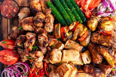 Canlı bir ızgara et, renkli sebze ve taze salsa, ahşap bir tepside düzenlenir. Bu lezzetli çeşitlilikte sulu tavuk, sığır eti ve taze ürün sergileniyor..