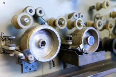 Karmaşık bileşenler ve viteslerle donatılmış klasik makinelerin yakın görüntüsü. Bu tarihi mekan, geçmiş üretim süreçlerinin işçilik ve mühendislik tekniklerini sergiliyor..