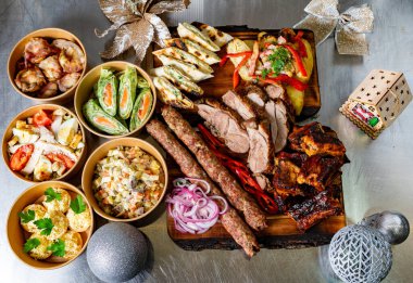 Müsrif bir ziyafet, ızgara etler, taze mezeler ve rengarenk kenarlar, hepsi bayram süslemeleriyle çevrili şenlikli bir toplantı için ahşap bir tahtaya dizilmiş..