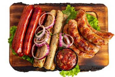 Ahşap tabakta, kırmızı, beyaz ve kahverengimsi sosisler, marul ve kırmızı soğanla süslenmiş taze salsa sosislerinin de yer aldığı çeşitli ızgara sosisler yer alıyor..