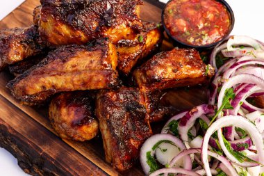 Lezzetli ızgara et kaburgalarının yanında baharatlı sos, taze soğan ve salatalık kırsal bir ahşap tahta üzerinde servis edilir. Barbeküde ya da aile toplantısında paylaşmak için mükemmel..