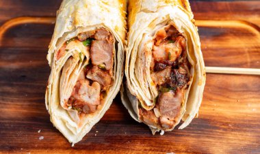 İki büyük paket lezzetli ızgara et, taze sebze ve sosla dolu, ahşap bir yüzeyde dinleniyor, canlı renkler ve baştan çıkarıcı dokular sergiliyor..