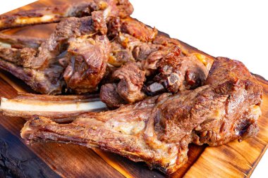 Yumuşak, mükemmel ızgara et kırsal ahşap bir tabakta duruyor. Açık hava pikniği için hazırlanmış sulu kesikler sergileniyor. Düzenleme, pişmiş etin davetkar kokusunu vurguluyor..