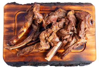 Kaba ahşap bir tabakta ustalıkla hazırlanmış ızgara domuz pirzolası seçimi. Et sulu ve iyi pişmiş, zengin kahverengi bir renk sergiliyor, sağlıklı bir yemek için ideal..