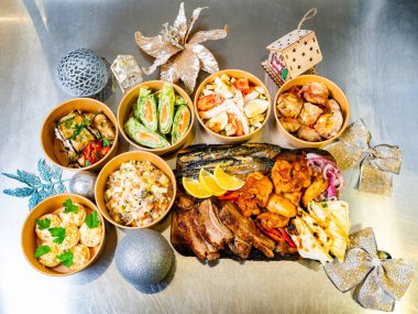 Tabaklarda ve tabakta servis edilen çeşitli rengarenk yemekler. Festival ortamında, neşeli bir toplantı için ideal dekorasyon ve mevsimlik eşyalar yer alıyor..