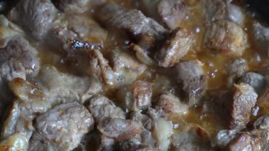 Cızırdayan et parçaları bir tavada pişiriliyor ve lezzetli aromalar yayıyor. Bu yemek pişirme süreci, mükemmel bir şefkat ve şefkate nasıl ulaşılacağını gösteriyor.