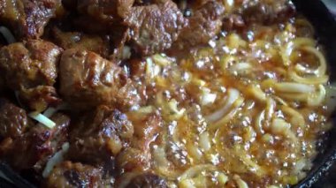Tavada soğanla kaynatılmış yumuşak sığır eti hazırlama sürecinin tadını çıkarın. Etin lezzetli lezzetleri nasıl emdiğine bakın. Her duruma uygun lezzetli bir yemek yaratıyor..