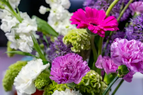 Çeşitli gölgelerdeki canlı çiçekler bir bahar pazarında görülen güzel bir buket oluşturur. Düzenleme narin çiçekleri ve yemyeşil çiçekleri içeriyor, mevsimsel güzellikleri gözler önüne seriyor..
