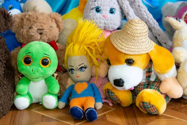 Canlı bir pelüş oyuncak çeşidi neşeli bir ortamda toplanır. Başrolde yeşil bir dinozor, parlak saçlı el yapımı bir oyuncak bebek ve hasır şapkalı dost canlısı bir köpek var..