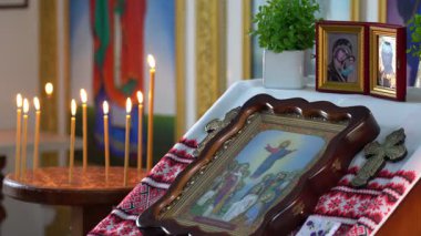 Dini simgelerin yanında hürmetle yakılmış sergilenen sergiler. Atmosfer huzurlu, ruhani uzayda bir yansıma ve bağlılık anını vurguluyor..