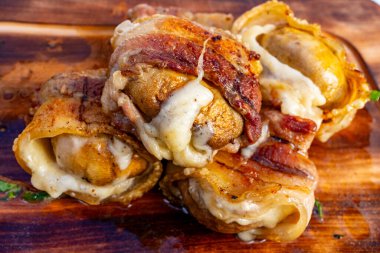 Erimiş peynirle dolu sulu mantarlar gevrek domuz pastırmasına sarılıp köy tahtasında dinleniyorlar. Sıradan bir toplantıda veya kutlamalarda paylaşmak için mükemmeller..