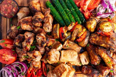 Taze sebze ve salsa ile birlikte tavuk ve sığır eti de dahil olmak üzere canlı bir ızgara gösterisi, toplanma için şenlikli ve iştah açıcı bir ziyafet hazırlıyor..