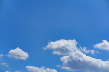 Pofuduk beyaz bulutlar güneşli bir öğleden sonra açık havada rahatlamak ve doğayı takdir etmek için mükemmel huzurlu bir atmosfer yaratırlar..