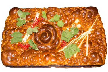 Karmaşık tasarımlarla süslenmiş zengin dekore edilmiş bir ekmek spiral bir süs eşyası içerir. Taze yeşillik ve böğürtlen süslüyor. Kutlama için mutfak sanatını sergiliyorlar..