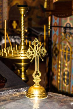 Tarihi bir kilisede sunağın üzerinde güzel işlenmiş altın bir haç duruyor. Çevreleyen elementler dekoratif tasarımlar ve sıcak, davetkar bir aydınlatma ile sakin bir atmosfer yaratırlar..
