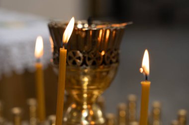 Karmaşık tasarımlarla süslenmiş altın mum tutacağı, titreyen mumlar tutar, toplanma sırasında dingin ruhsal bir atmosferde sıcak bir parıltı bırakır..