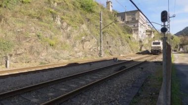 Os Peares, Ourense, İspanya; 05-12-2022: Renfe şirketinin genel izole edilmiş lokomotifi Os inci istasyonuna giriş yapıyor ve çıkış işaretinin yanından geçiyor