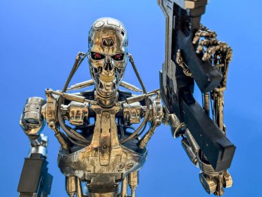 Madrid, İspanya; 01-03-2024: Terminatör filminden bir T-800 'ün gerçek boyutunda bir figür, insan örtüsünden soyulmuş, sadece bir elinde silah taşırken robotik iskeletini bırakıyor.