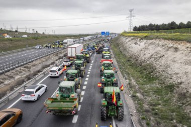 Illescas, Toledo, İspanya; 02-07-2024: Toledo ilindeki A-42 otoyolunu kesen traktörler, İspanyol çiftçilerin tehlikeli durumları nedeniyle trafik gecikmelerine yol açtılar
