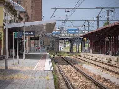 Ponferrada, Leon, İspanya; 07-29-2024: 1 ve 2 numaralı rayların boş olduğu Ponferrada istasyonu güneşli bir yaz gününde yolcu bekleyen platformlar ve trenleri bekliyor.