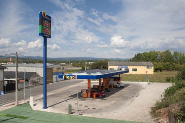 Ponferrada, Leon, İspanya; 08-30-2024: Plenoil SL şirketinin düşük maliyetli benzin istasyonunun hava görüntüsü araçların yakıt ikmali sırasında ve dikey bir panel yakıt fiyatını gösteriyor