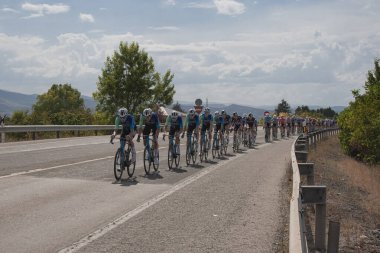 Ponferrada, Leon, İspanya; 08-30-2024: Bir grup bisikletçi (peloton) 2024 Vuelta a Espaa safhasında Ponferrada şehrinden geçerken Decathlon takımı tarafından yönetiliyor.